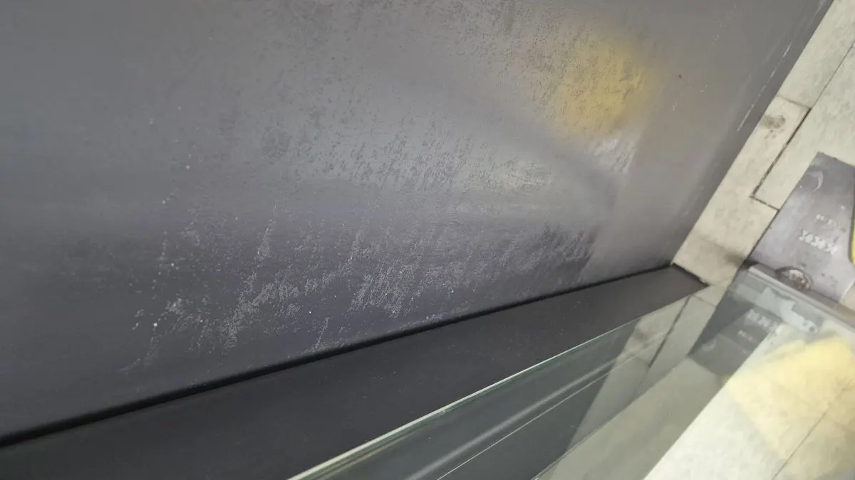 도색된 건물 출입문에 접착제 잔여물이 남아 있는 상태