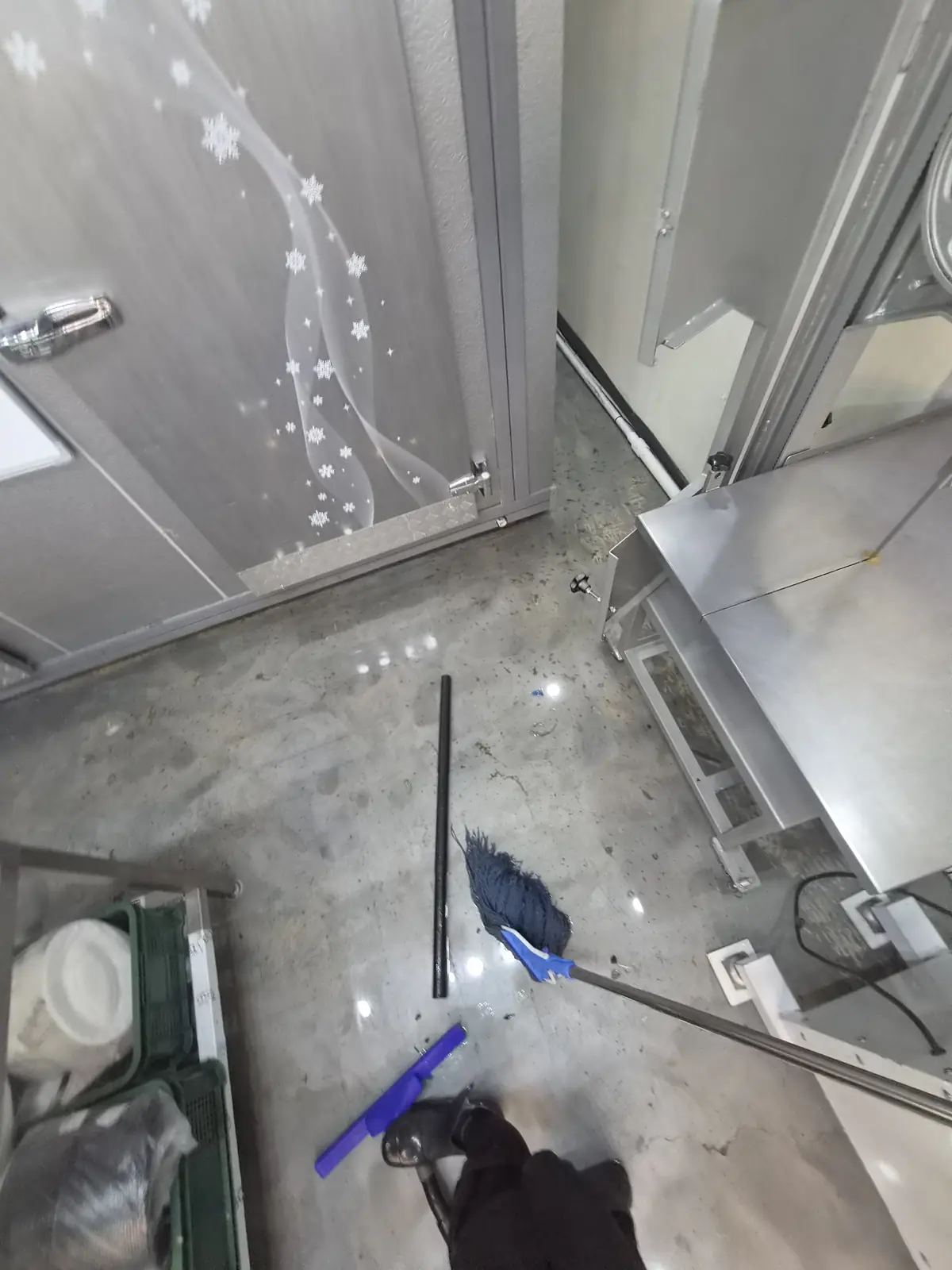 새벽 도착 직후 정육점 바닥의 잔여 오수를 스퀴지로 모으기 시작하는 초기 작업 장면