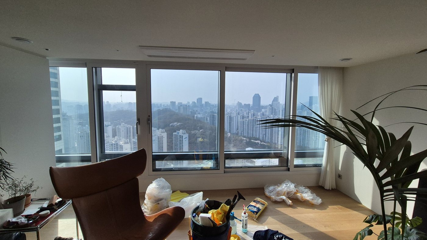 유리 필름 제거 완료 — 거실 전경, 서울 도시 뷰 선명