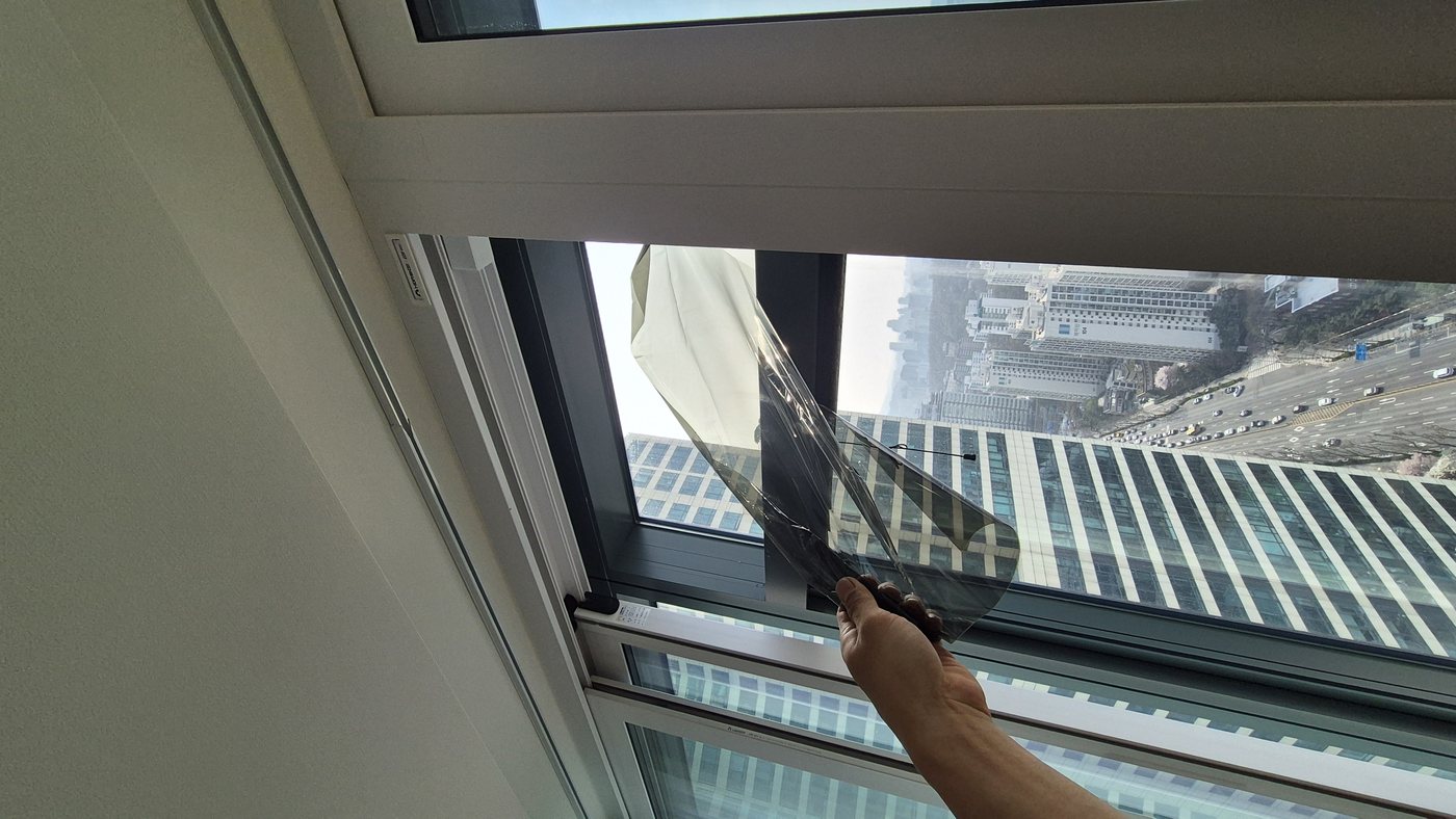 유리 썬팅 필름 직접 박리 중 — 들뜬 필름 제거