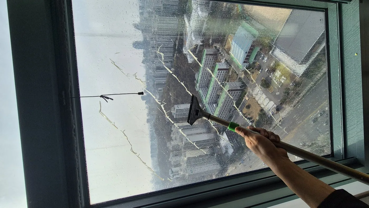 유리 접착제 끈끈이 스퀴지로 제거 중