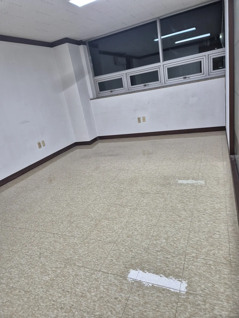 왁스를 바른 뒤 천장 조명이 비치는 사무실 방 타일 바닥과 벽 위쪽 창
