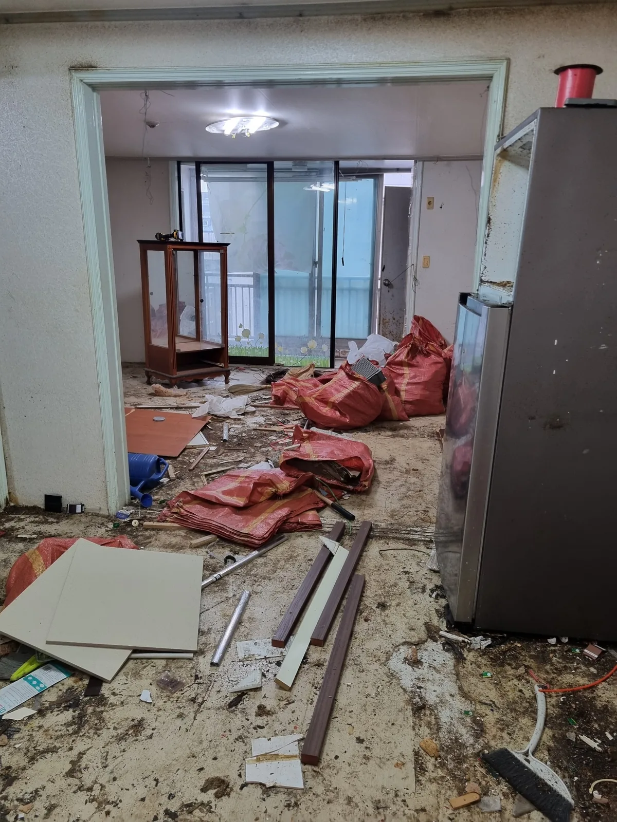 실내 정리가 진행된 상태 — 걷어낸 자재와 폐기물을 마대에 담아 반출을 준비한 단계