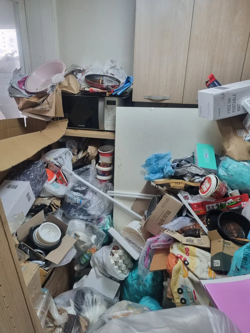 주방 조리 공간이 포장 용기와 봉투로 덮여 조리대가 보이지 않는 상태