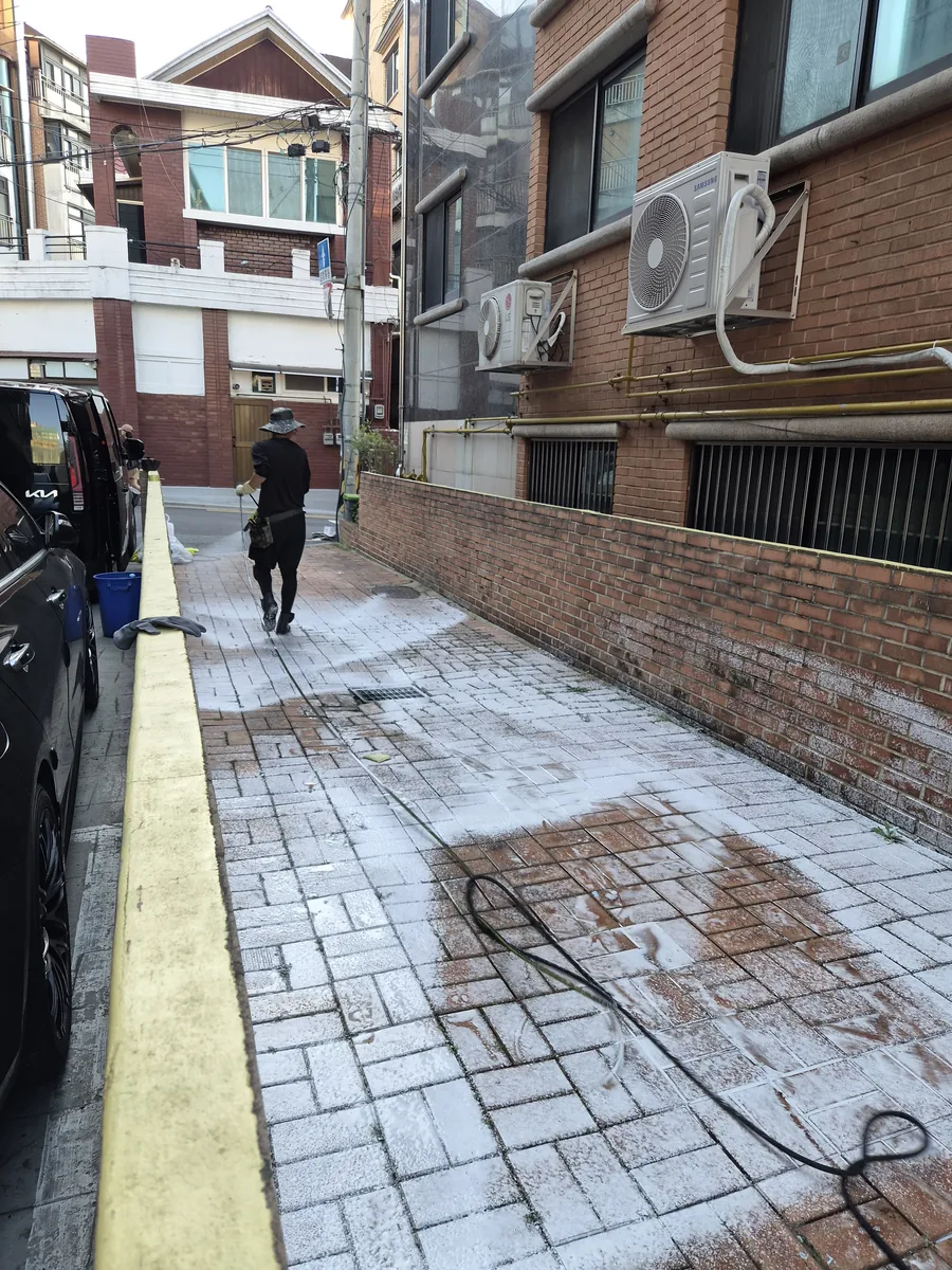 공사 기름 피해 통로 물청소 완료 후 깨끗해진 벽돌 바닥