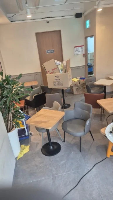 카페 적재 박스 소화기 분말 오염 — 분말이 쌓인 박스와 바닥 작업 전