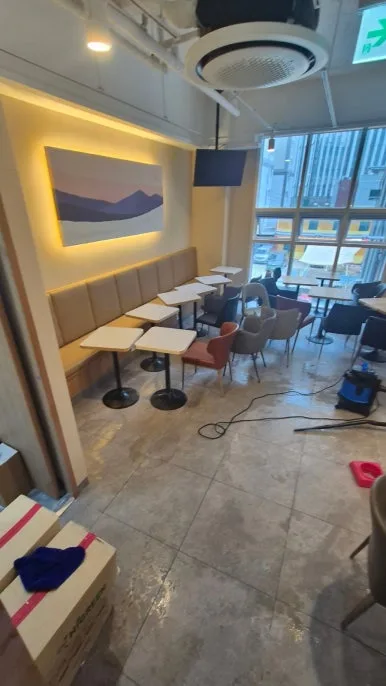 카페 객석 소화기 분말 제거 중 — 테이블·의자에 쌓인 분말 닦아내는 작업