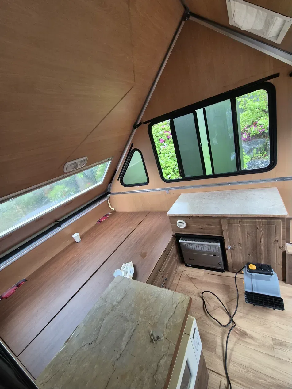 남양주 카라반 화재청소 작업자 흡입기로 침대 하부 세정 중