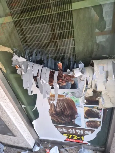 유리창에 부착된 광고 시트지와 테이프 잔여물